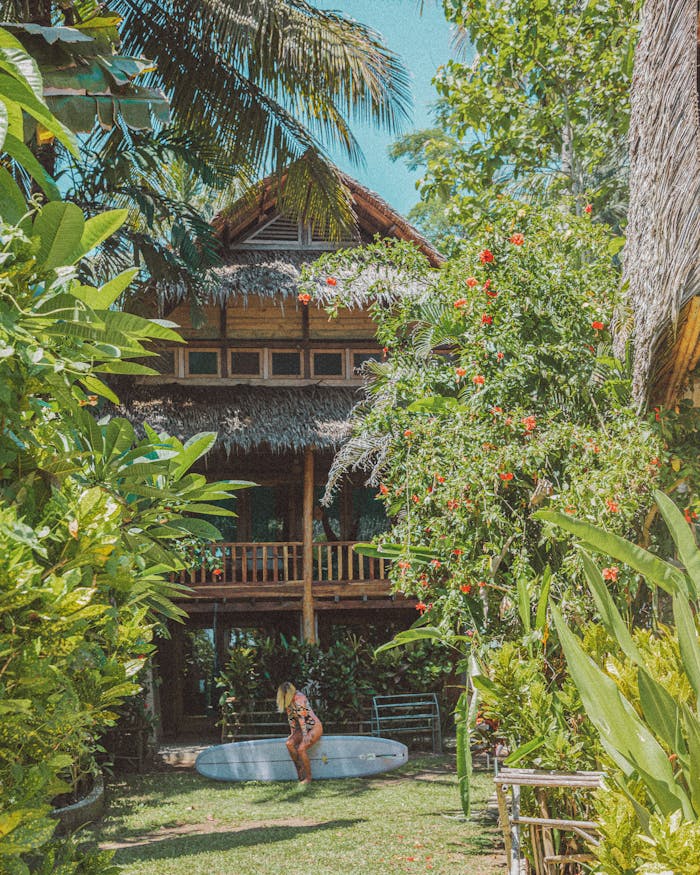 our-story Beautiful tropical villa surrounded by lush greenery and a surfboard, perfect for a luxury vacation.