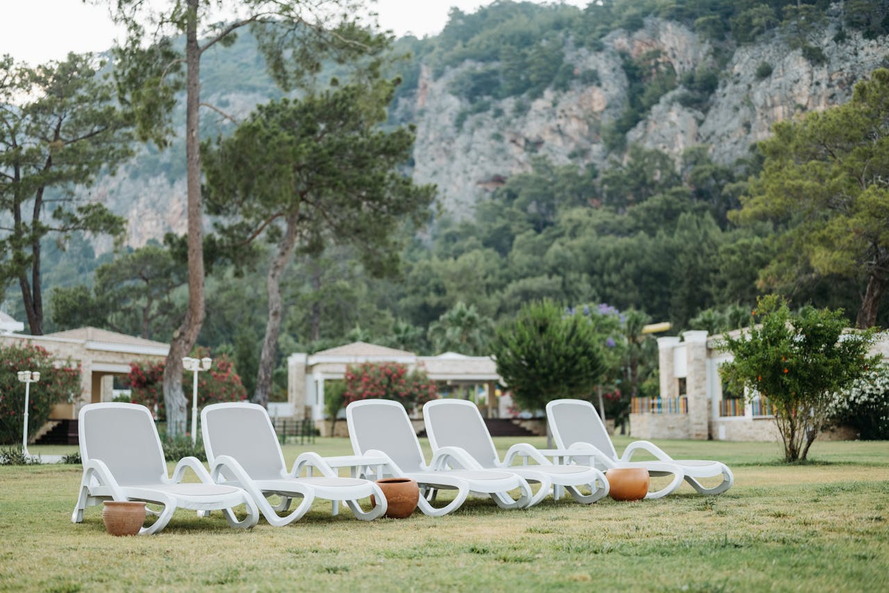 get-in-touch Peaceful resort garden with sunbeds and lush mountain backdrop, ideal for relaxation.